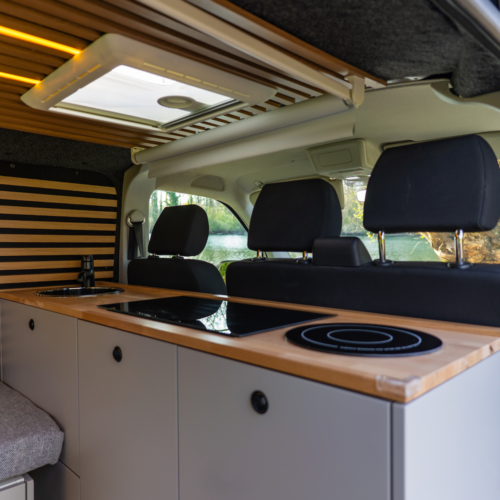 Espace cuisine van aménagé Black Van plan de travail bois évier induction